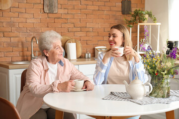 Poster - Young woman with her grandmother drinking tea in kitchen