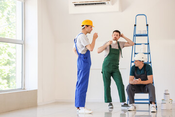 Canvas Print - Team of male builders during coffee break in room