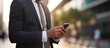 © theevening - Business man in a suit watching smart mobile phone device in city outdoors