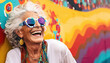 Very bright and happy old woman laughing in stylish glasses on a multi-colored background