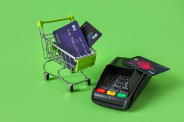 Sticker - Shopping cart with payment terminal and credit cards on green background