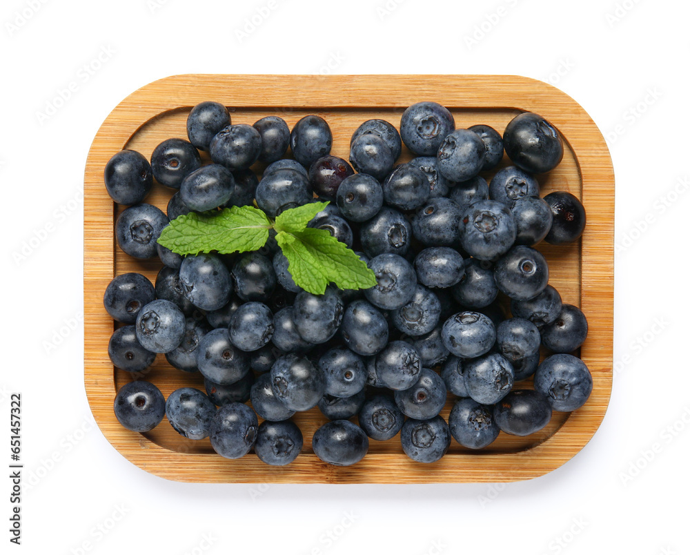 Wooden board with fresh blueberries and mint on white background