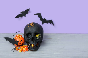 Canvas Print - Skull, paper bats and bowl with tasty candy corns for Halloween celebration on grey wooden table