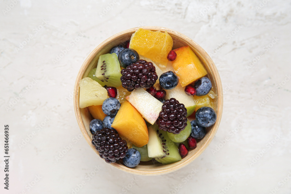Bowl of fresh fruit salad on light background