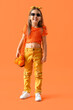 Leinwandbild Motiv Stylish little girl with string bag on orange background