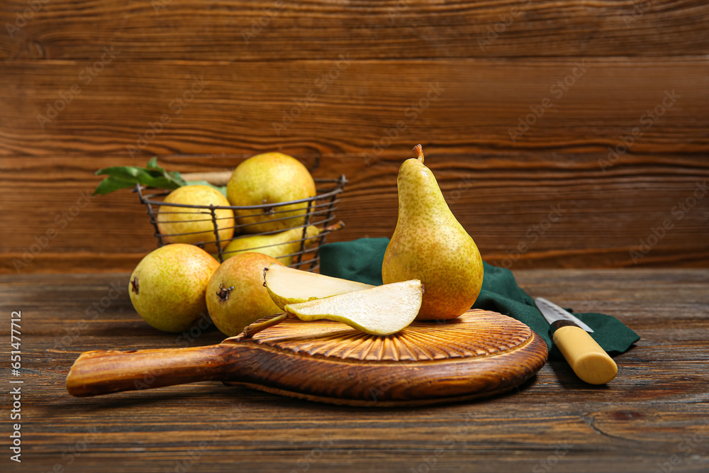 Board with ripe pears on wooden background