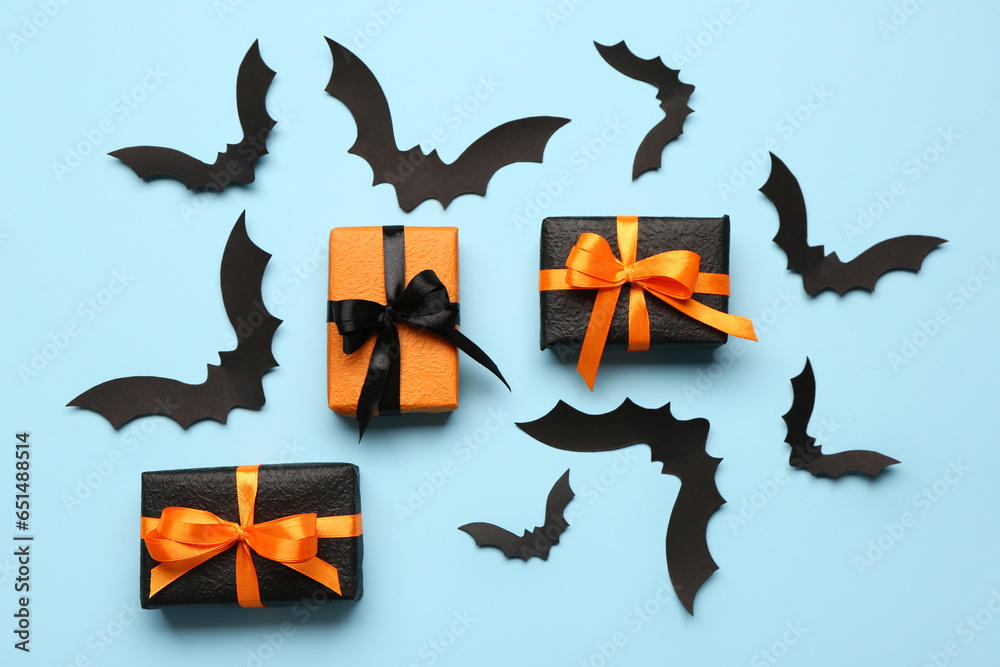 Paper bats for Halloween party and gift boxes on blue background