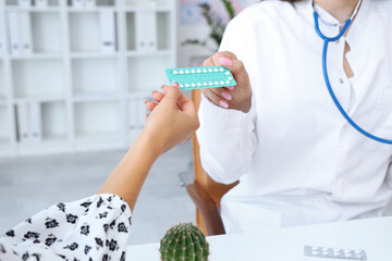 Canvas Print - Female gynecologist giving contraceptive pills to patient in clinic, closeup