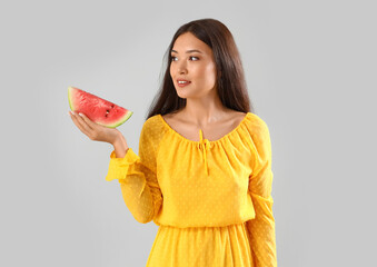 Poster - Beautiful young Asian woman with slice of fresh watermelon on grey background