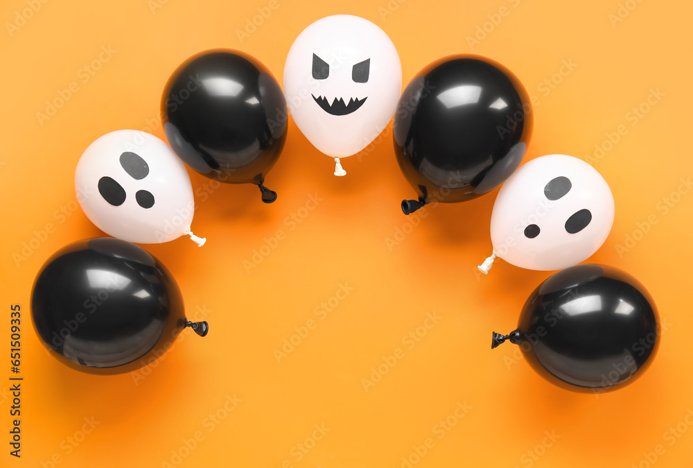 Different funny Halloween balloons on orange background