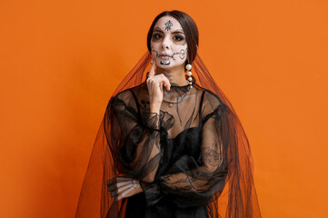 Poster - Beautiful young woman dressed as dead bride for Halloween party on orange background