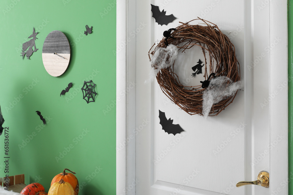 White door with wreath in hall decorated for Halloween