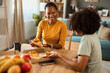 © Stockphotodirectors - Mother and teenage son having pizza at home