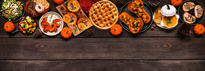 Poster - Delicious autumn meal top border. Above view on a dark wood banner background. Stuffed pumpkins and squash, sweet potatoes, appetizers, soup, vegetables and apple pie.