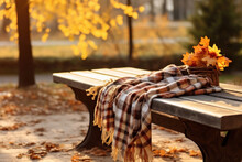 A Wooden Bench With A Forgotten Blanket And A Bouquet Of Leaves In A Deserted Autumn Park Flooded With Sunlight