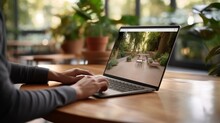 A Hyper-realistic Scene Featuring A Laptop With A Pristine Mockup Screen, Elegantly Placed On A Sleek Wooden Table, While A Woman's Hands Interact With It.