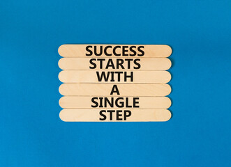 Wall Mural - Success symbol. Concept words Success starts with a single step on wooden stick. Beautiful blue table blue background. Business success starts with a single step concept. Copy space.