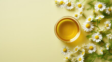 Top view of glass cup with soothing chamomile tea on flat yellow pastel background with copy space, chamomile flowers. 