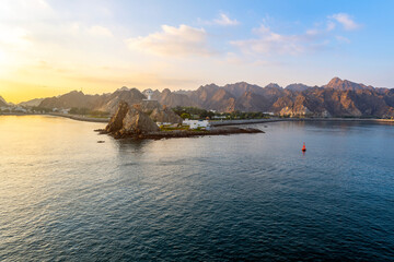 View of the Marine Watch Tower, Riyam Incense Burner and the tiled waterfront Corniche Promenade from sea on an early morning in Muscat, Oman.