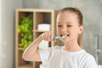 Wall Mural - Cute little girl brushing her teeth with plastic toothbrush in bathroom, space for text