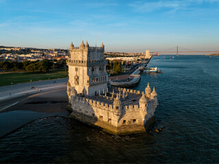 Wall Mural - Aerial view of Belem Tower famous tourist landmark of Lisboa and tourism attraction on the bank of the Tagus River (Tejo) with tourist boats at sunset. Lisbon, Portugal