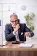 © Elnur - Old male employee working in the office