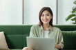 © CYBERUSS - Portrait of Young Asian Woman with Laptop in Living Room, Beautiful Businesswoman Work From Home, Happy Female Enjoy a Free Day, Online Shopping and Watching Movies