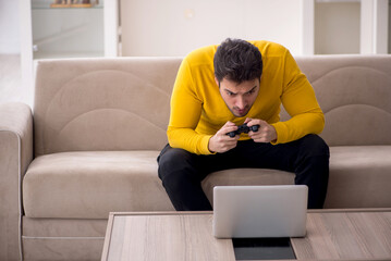 Wall Mural - Young man playing video games at home