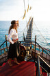 a beautiful girl in a pirate costume on the deck of a ship