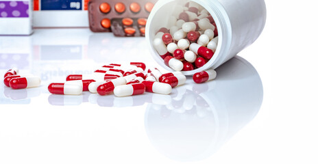Wall Mural - Red and white capsules pill spilled out from white plastic bottle. Prescription drug. Healthcare and medicine. Antibiotics drug. Antimicrobial capsule pills. Pharmaceutical industry. Pharmacy product.