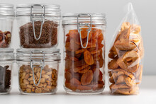 Food Storage, Healthy Eating And Diet Concept - Close Up Of Jars With Dried Fruits, Seeds And Nuts On Table