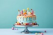 Festive birthday colorful cake decorated with sweets, macarons on a blue background.