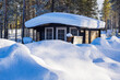 Landschaft mit Schnee und Holzhütte im Winter in Kuusamo, Finnland