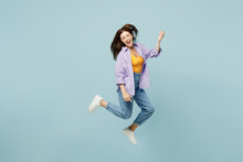Full Body Young Happy Woman She Wearing Purple Shirt Yellow T-shirt Casual Clothes Jump High Pretend Playing Guitar Isolated On Plain Pastel Light Blue Background Studio Portrait. Lifestyle Concept.