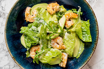 Wall Mural - caesar salad with shrimps  on blue plate