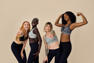 Poster - Happy fit sporty diverse different girls group having fun posing at beige background. Multiracial positive young women friends wear sportswear advertising fitness gym yoga body trainings together.