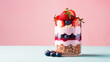 Sweet fresh dessert, Layered strawberry and blueberry yogurt with healthy oatmeal flakes in a glass jar on flat pastel background with copy space. 
