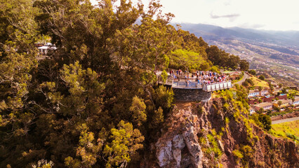 Poster - Tourists enjoy the viewpoint at Cabo Girao, along the Madeira coastline, Portugal. Aerial view from drone