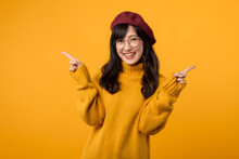 Stylish Young Woman In A Red Beret And Yellow Sweater Against A Vibrant Yellow Background, Showcasing A Fashion Choice.