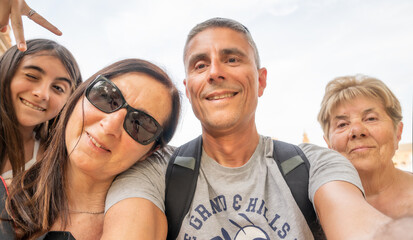 Wall Mural - A family of four people outdoor taking selfies on a trip