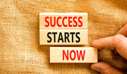 Wall Mural - Success starts now symbol. Concept word Success starts now on beautiful wooden block. Businessman hand. Beautiful canvas table background. Business motivational success starts now concept. Copy space.