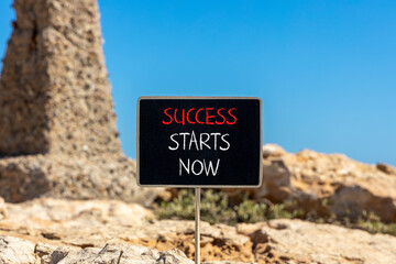 Wall Mural - Success starts now symbol. Concept word Success starts now on beautiful black blackboard. Beautiful brown stone blue sky background. Business motivational success starts now concept. Copy space.