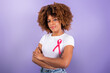 canvas print picture - Black Woman With Pink Ribbon Over Purple Background In Studio