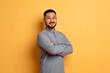 © Prostock-studio - Portrait of confident asian man standing with folded arms on yellow background