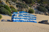 Fototapeta Na ścianę - Greek flag painted on a rock. Tsambika beach on the island of Rhodes.