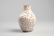 A white ceramic vase with a gold crackle pattern on a grey background.