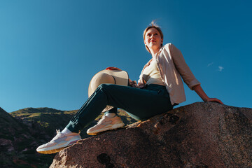 Sticker - Young woman hiker sitting on top of the mountain