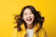 © vefimov - Woman wearing yellow jacket is captured in moment of laughter. This image can be used to depict joy, happiness, or lighthearted atmosphere in various projects.