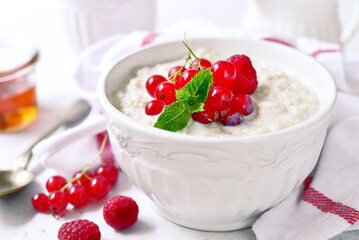 Wall Mural - Oatmeal porridge with fresh berries and maple syrup for a breakfast.