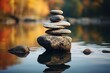 Balancing zen stone pyramid on the shore of a bright autumn forest lake